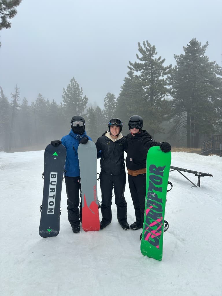 Snowboarding with friends on a foggy mountain