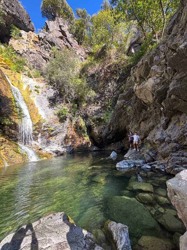 At a waterfall with clear green pool water
